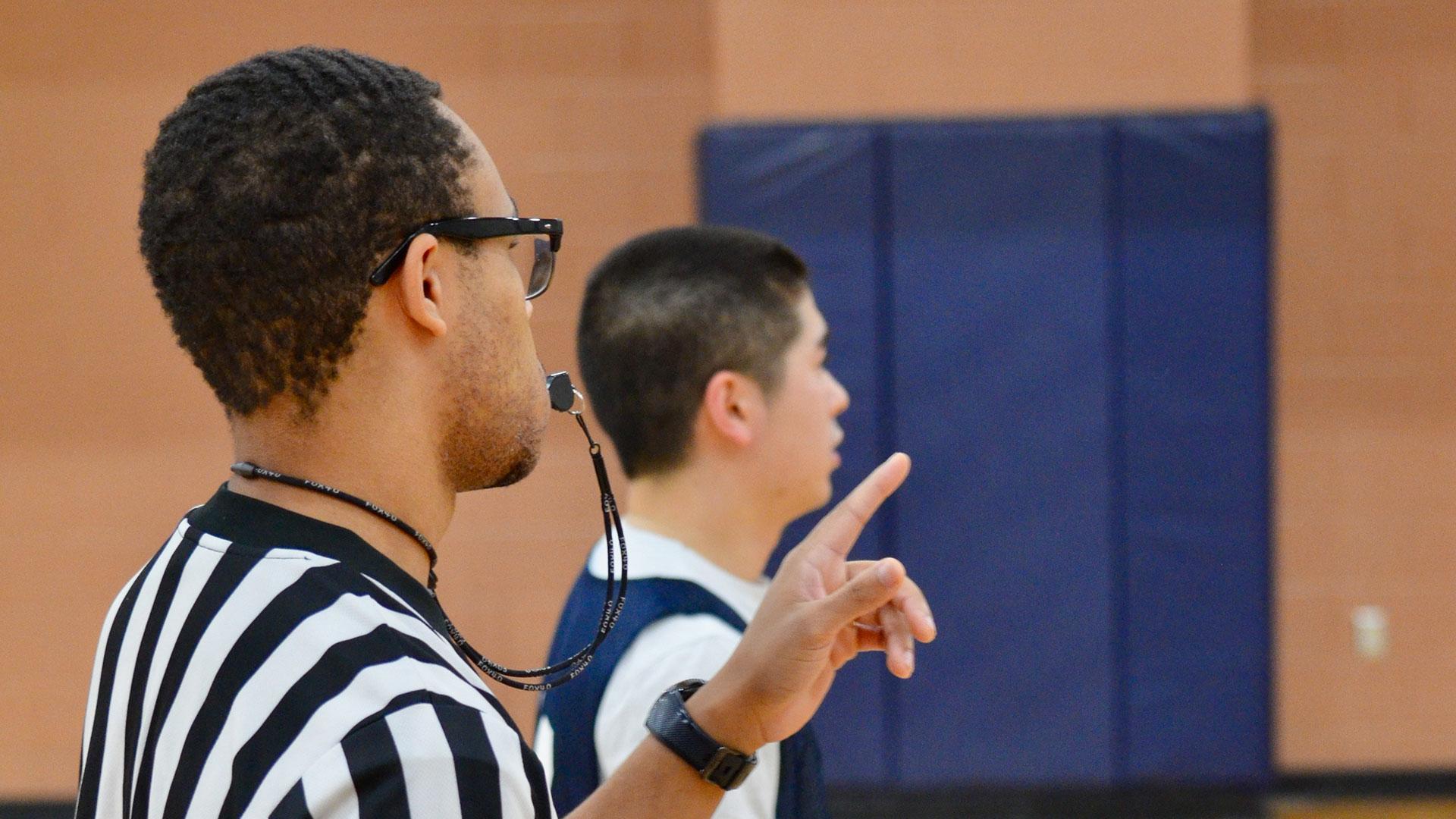 student staff referee at an intramural basketball game
